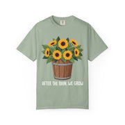 Bucket of sunflowers with After the Rain, We Grow underneath, on a bay green shirt