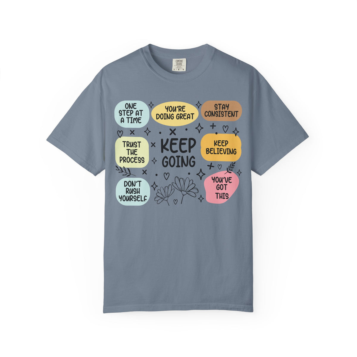 Keep Going affirmations in pastel blocks on a blue jean women's shirt