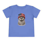 Otter in a USA flag knitted beanie, on a heather columbia blue toddler shirt