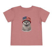 Otter in a USA flag knitted beanie, on a heather mauve toddler shirt