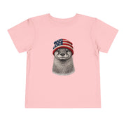 Otter in a USA flag knitted beanie, on a pink toddler shirt